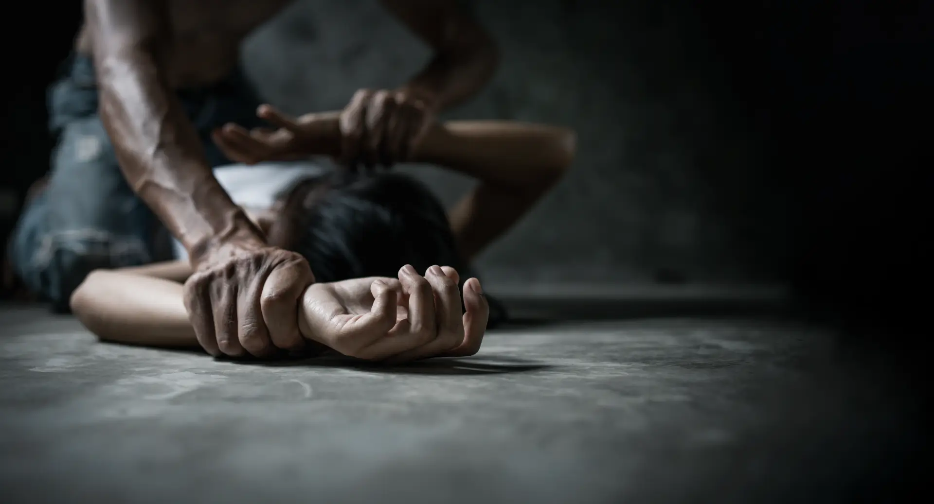 woman being forcefully held on the ground